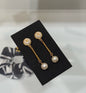 DreamStudio CHANEL gold-tone drop earrings featuring interlocking logo motifs and cream pearl accents on a black card.