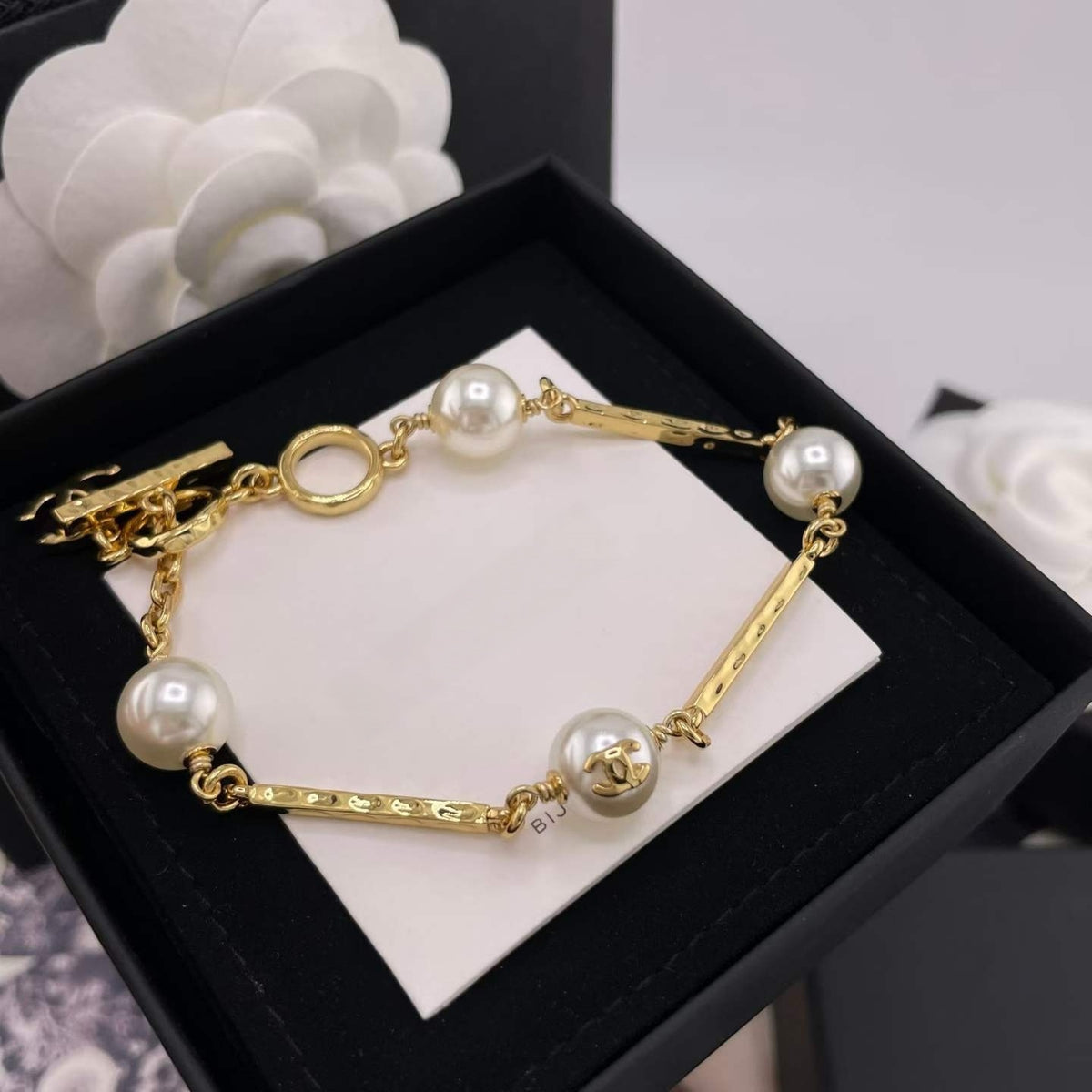 DreamStudio CHANEL gold-tone link bracelet featuring lustrous faux pearls and logo-embossed metal bars in a gift box.