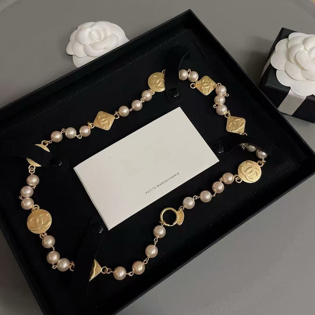 DreamStudio CHANEL necklace with cream faux pearls, gold-tone medallions, and black velvet ribbon in a gift box.