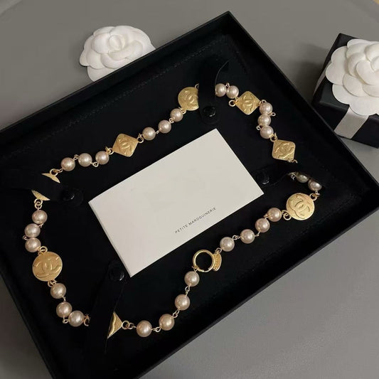 DreamStudio CHANEL necklace with cream faux pearls, gold-tone medallions, and black velvet ribbon in a gift box.