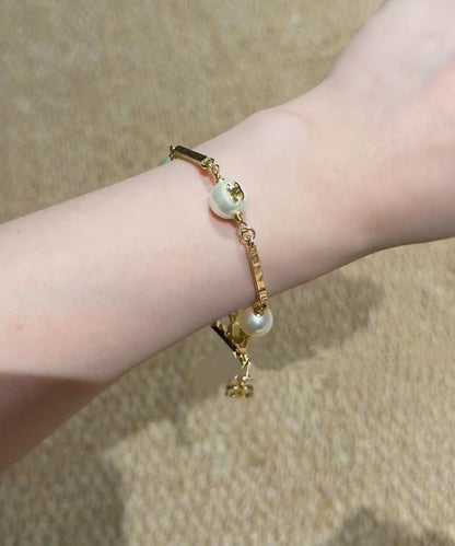 DreamStudio CHANEL gold-tone link bracelet featuring lustrous faux pearls and iconic logo-embossed metal accents