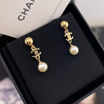 DreamStudio CHANEL gold-tone drop earrings featuring the iconic interlocking logo and cream faux pearl accents.