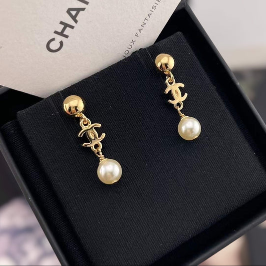 DreamStudio CHANEL gold-tone drop earrings featuring the iconic interlocking logo and cream faux pearl accents.