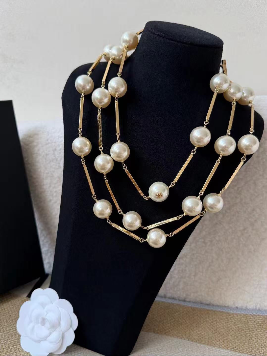 DreamStudio multi-strand statement necklace featuring lustrous faux pearls and gold-toned metallic bars on a display